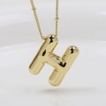 Close-up of golden puffy 3D initial H pendant with a smooth polished metallic finish - Letter H (Necklace)