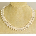 Elegant multi-strand white freshwater pearl tassel necklace on a textured bust model - Fishing Line Double Woven Style