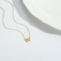 Detail view of a dainty gold letter W pendant necklace on a minimalist chain - Letter W