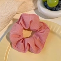 Pink pleated ribbon scrunchie with soft fabric texture on a cream decorative plate - Puff Pink