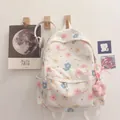 Detailed view of the cute floral print and plush flower pendant on the white backpack - White Flower