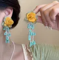 Detailed view of yellow rose tassel earrings with fabric petals and green bead strands - Bright Yellow Fabric Rose Tassel Style (No. 22 Silver Earring Post - Green)