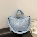 Light blue quilted puffer tote bag with large square stitching and padded shoulder strap - Blue