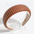 Detail of brown PU leather headband with metallic silver cone studs on a clear stand - Dark Brown
