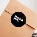 Black round sticker with white thank you text on brown cardboard packaging box - Round Black Stickers (6 Pieces per Sheet)