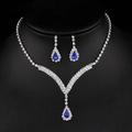 Sparkling bridal jewelry set featuring a blue gemstone necklace and drop earrings on a bust - Royal Blue