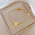 Gouden vlinderarmband van roestvrij staal gepresenteerd op witte zijden achtergrond - Goud