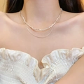 Detail of double-layer silver bow necklace with elegant zircon beads on a female model - Double Layer Snake Chain Stack (X1202) / Silver/Crushed Silver Style