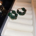 Macro shot of green crystals set on dark metal hoop earrings in a jewelry box - Style 10 Gun Black Green Gem