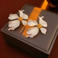 Vintage bloem oorknoppen in wit en goud mat op een luxe sieraden doosje getoond - Zilver