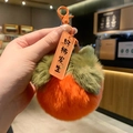 Détail du porte-clés en peluche kaki avec feuilles vertes et fermoir orange - Persimmon Bonne Chance