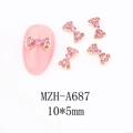 Detail view of 10x5mm gold bow nail charms with pink rhinestones on a manicure - A687