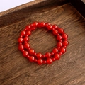 Detail of red agate beaded bracelet on a dark wood tray with natural polished finish - Double Strand Small Bead Long Style