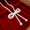 Close-up of pearl bow necklace in red velvet gift box with elegant golden accents - Small White Imitation Pearl Bow Necklace
