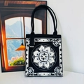 Close-up of thick knitted tote bag featuring black and white lotus geometric patterns - Black