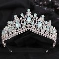 Close-up of Baroque silver bridal crown with blue gemstones on black velvet background - Silver White Rhinestone + Green Opal