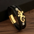 Close-up of black lizard leather braided bracelet with gold lizard charm and magnetic clasp - 21cm / Black + Gold