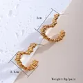 Macro shot of gold-plated geometric C-shaped earrings measuring 3cm by 2.4cm - Heart