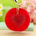 Detail of red plush ball and rhinestone heart charm on a golden metal keychain - Red Heart + Red Pom Pom