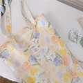 Detailed close-up of the colorful floral print and fabric label on a white cotton tote bag - Yellow-Orange Floral