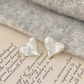 Close-up of silver heart stud earrings featuring a textured lava molten metal finish - Lava Heart / Silver