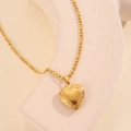Detail of 18k gold plated heart locket pendant on Figaro chain over stone background - Gold Style (JZ-N246201G)