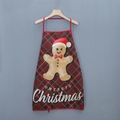 Detail showing gingerbread man print and Merry Christmas text on plaid holiday apron - Plaid Gingerbread Man Style