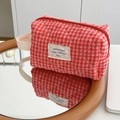 Détail de la trousse à maquillage matelassée à carreaux rouges avec poignée en coton blanc - Pochette de Poignet Matelassée à Carreaux Baies Rouges