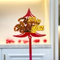 Close-up of red acrylic Christmas tree cake topper with shiny gold Merry Christmas text - Red Gold Christmas Tree 2 Merry Christmas
