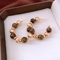 Macro shot of 16K gold-plated C-shape earrings with tiger eye beads in a jewelry box - Gold-Brown Tiger's Eye (WE5117)