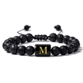 Détail du bracelet en pierre de lave avec initiale M dorée sur breloque polie - Lettre M(M)