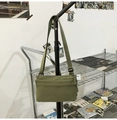 Detail of army green nylon crossbody bag with layered front pockets and adjustable strap - Green