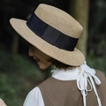 Eleganter flacher Strohhut mit schwarzem Band für Damen getragen von einem Modell - 5cm Krempe / Natur mit schwarzem Band