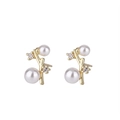 Elegante gouden tak oorknopjes met witte parels en sprankelende zirkonia accenten - Goud