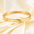 Vista detallada de un brazalete de acero inoxidable dorado pulido de 6mm sobre seda - Dorado