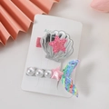 Detalle de pinzas para el pelo de concha y sirena en tarjeta con perlas y estrellas - Juego colorido