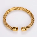 Nahaufnahme der goldenen Kabelstruktur auf dem verstellbaren Edelstahl-Manschettenarmband - Gold