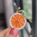 Fashionable orange slice enamel brooch with golden plating and green leaf detail - Orange Lemon
