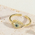 Primer plano del anillo de ojo turco dorado con circón azul y detalles de pestañas - Ojo Turco de Circonita Azul