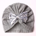 Detailed top view of a grey knit baby turban hat with a shiny silver sequin bow - Gray