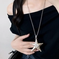 Dettaglio di un grande ciondolo a stella marina d'argento con trama martellata su modella - 2# Collana - Argento - Forma di stella marina
