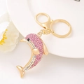 Detail of a golden dolphin keychain with pink rhinestones on a decorative white dish - Dolphin 2 (Pink)