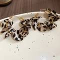 Detail von Ohrringen mit Stoffblumen im Leopardenmuster und Bernsteinperlen auf Teller - Ohrringe-Kaffee-Leopardenmuster