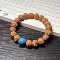 Rudraksha seed bracelet featuring natural brown beads and a turquoise blue accent bead - Vajra (Turquoise Round Bead)