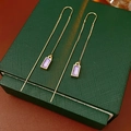 Detalle de pendientes de cadena dorada con esmalte púrpura en una caja de regalo - Dorado/Púrpura