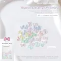 Macro shot of 7.6x10mm aurora resin bow nail charms in various macaron colors with glitter - Bow Tie (SP-1119)