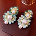 Detailed view of vintage flower earrings with blue crystals and pearls on a leather case - 5cm*3cm / Silver Earring Post-Green