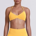 Detail of seamless bright yellow halter sports bra with ruched center and smooth texture - Yellow