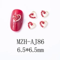 Vue macro de bijoux d'ongles coeur évidé 6,5mm avec strass rouges et base dorée - Cœur Creux Élégant (AJ86)