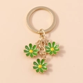 Sweet green daisy keychain with three floral pendants and a polished golden ring - Green